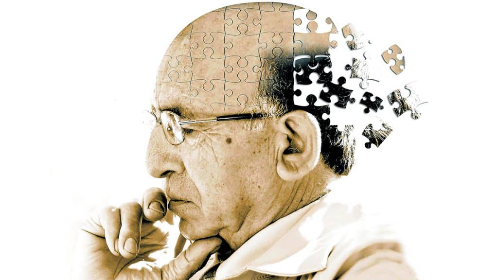 Ilustração de idoso se desfazendo em peças de quebra-cabeça para retratar conceito do Alzheimer