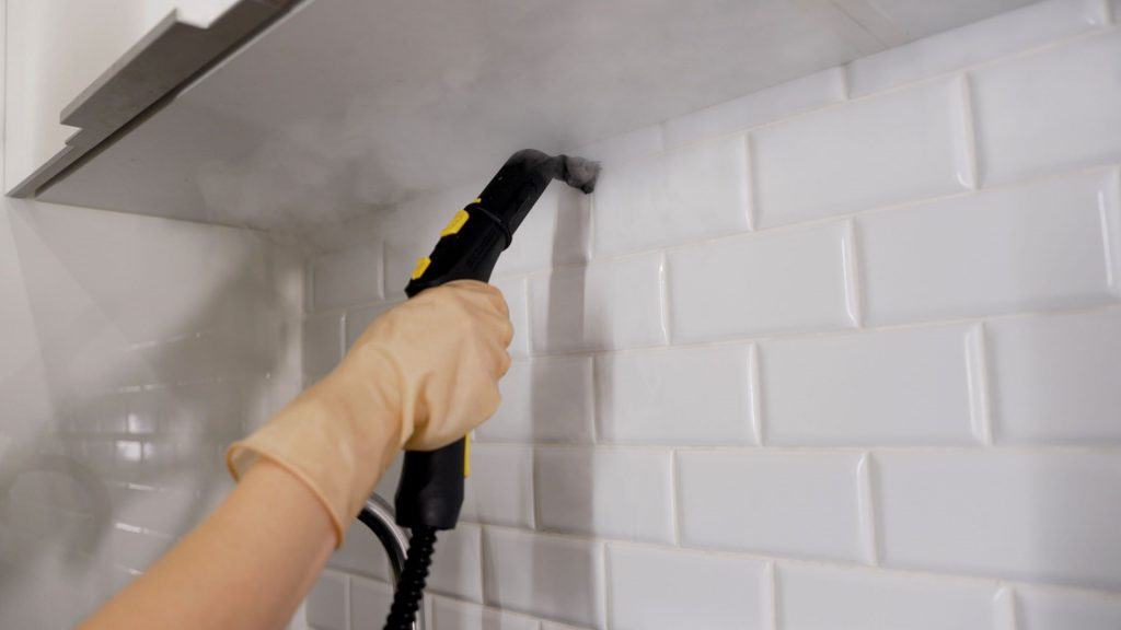 A limpeza a vapor quente remove a sujeira das juntas no cozinha. Limpando as emendas dos azulejos de cerâmica da sujeira, limpando pela casa. Limpando azulejos de cerâmica com pressão d'água.