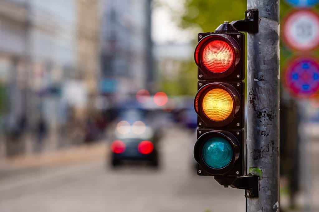 cruzamento da cidade com um semáforo, luz vermelha e laranja no semáforo, controle de tráfego