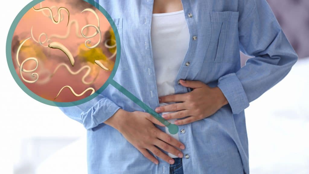 Ilustração de uma mulher com dor no intestino causada por parasitas intestinais 