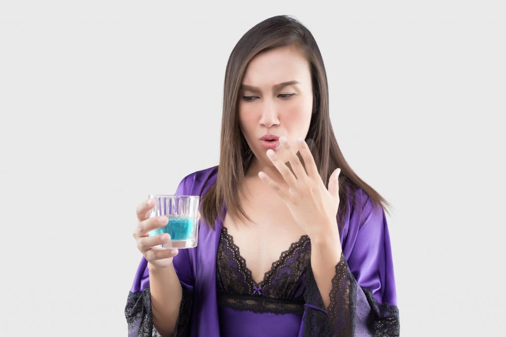 Mulher com boca ardida após usar enxaguante bucal