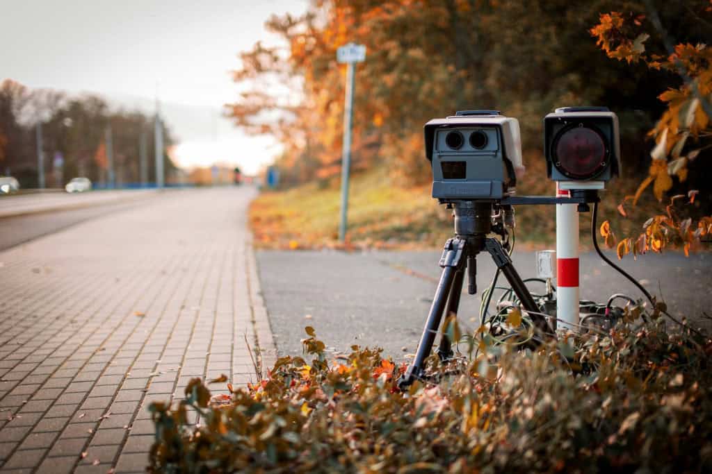 imagem mostra um radar fixo acoplado no canto da estrada para verificar a velocidade dos carros
