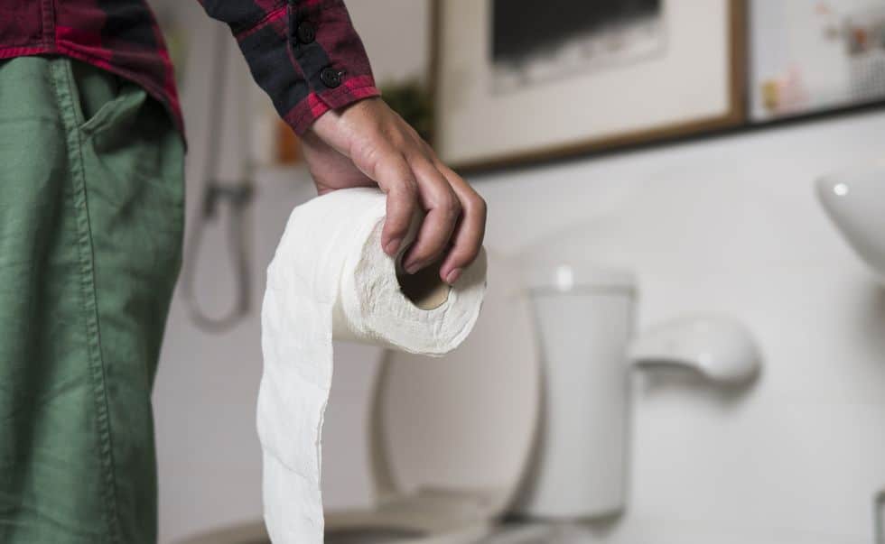 Homem segurando papel higiênico