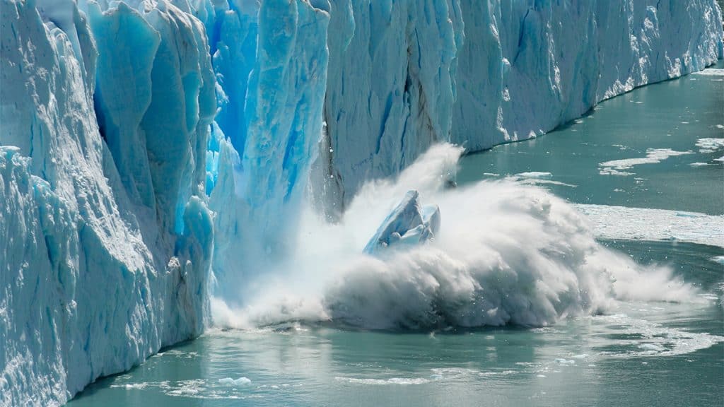 Pedaço de geleira despencando no mar por conta das mudanças climáticas
