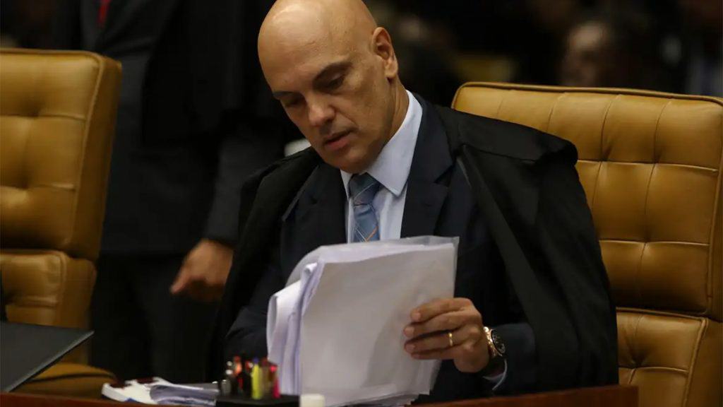 Ministro do STF Alexandre de Moraes lendo documentos