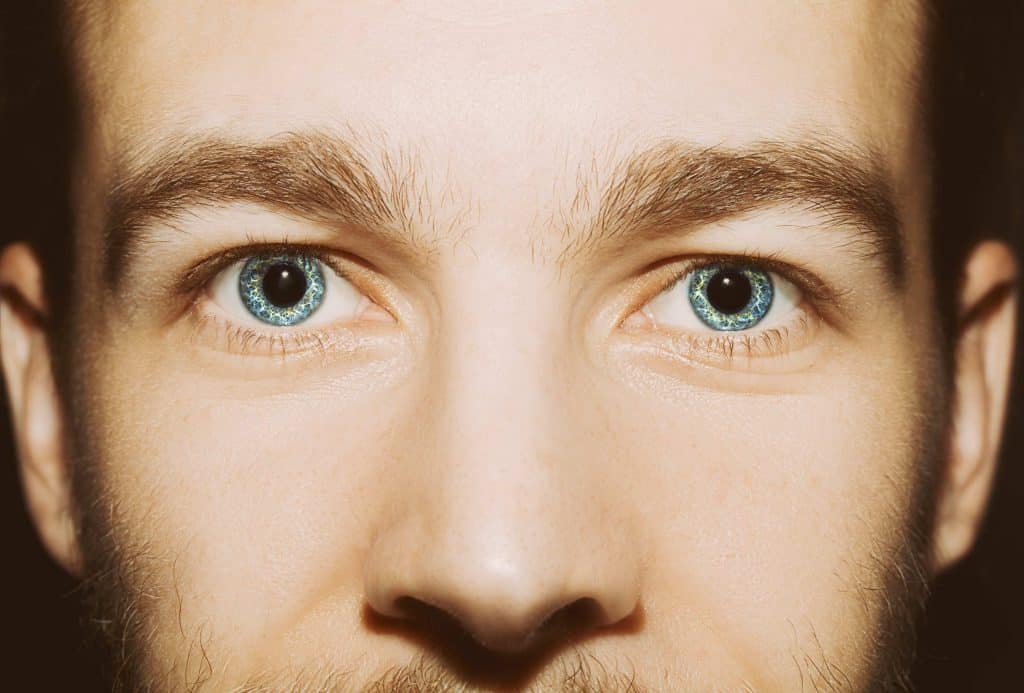 Homem de olhos azuis com as pupilas dilatadas