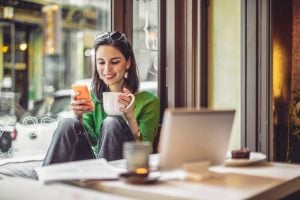 Mulher da geração Z sentada em café com computador